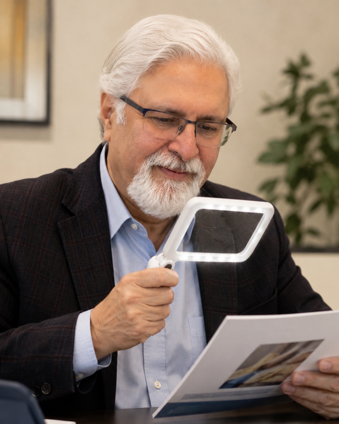Dr. Siddiqui reviewing material with an illuminated magnifier